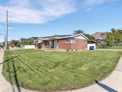 Duplex exterior featuring driveway, brick siding and covered porch