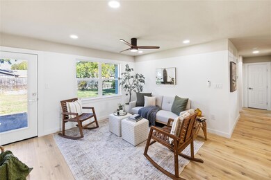 Living room with ceiling fan and light hardwood / 