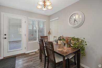 Dining area featuring dark wood-type flooring and a chandelier