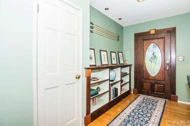 Entryway with charming front door, and hardwood fl
