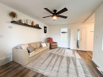 Living room with wood finished floors and a ceiling fan