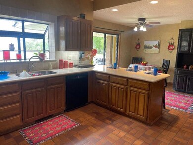 Kitchen featuring ceiling fan, sink, backsplash, b