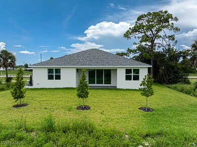 Rear view of property with a shingled roof, stucco