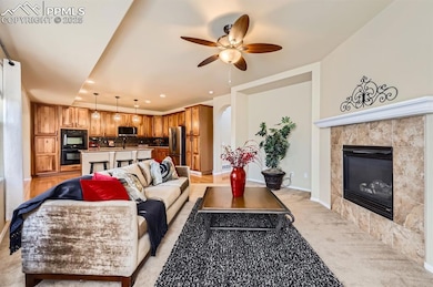 Living room with a ceiling fan, a tile fireplace, 