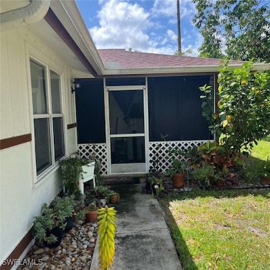 View of exterior entry with a shingled roof