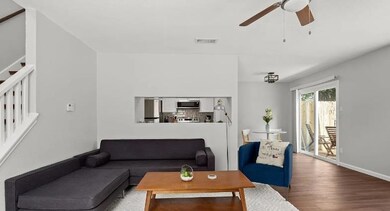 Living area featuring stairway, a ceiling fan, wo