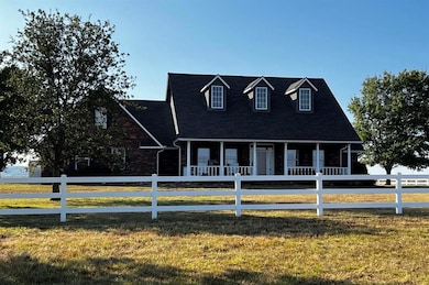 Cape cod home with a porch and a front yard