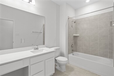 Secondary bath features tile flooring, bath/shower