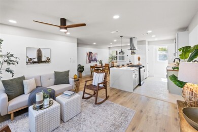 Living room with ceiling fan and light wood-type f