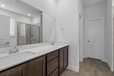 Bathroom featuring a shower with door, vanity with
