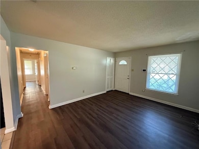 Foyer with dark wood-style flooring and a textured ceiling