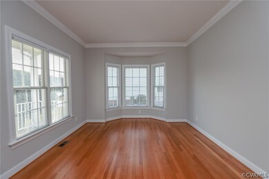 Unfurnished room with crown molding and light wood