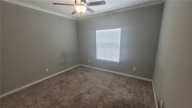 Carpeted spare room with ceiling fan and crown mol