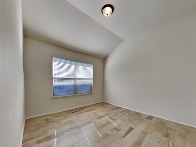 Spare room featuring lofted ceiling and wood tiled floors