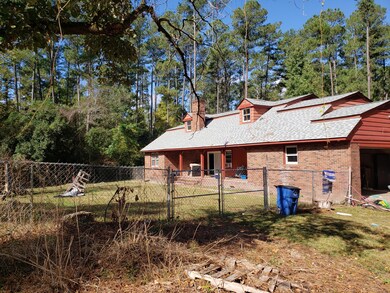 Back has covered porch and fencing