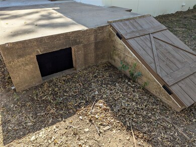 Kitchen featuring sink, white cabinetry, stainless steel appliances, light stone counters, and dark luxury vinyl floors