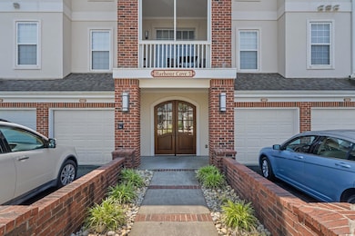 View of exterior entry with a garage, brick siding