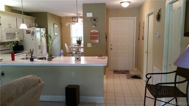 View of kitchen and front door from patio door in