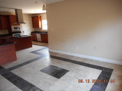 Kitchen featuring island range hood, inlaid floor details, and decorative light fixtures