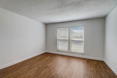 Empty room with hardwood / wood-style floors and a