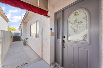 View of exterior entry with stucco siding and a patio area