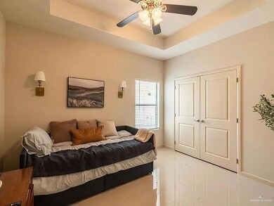 Bedroom with a closet, ceiling fan, and a tray ceiling