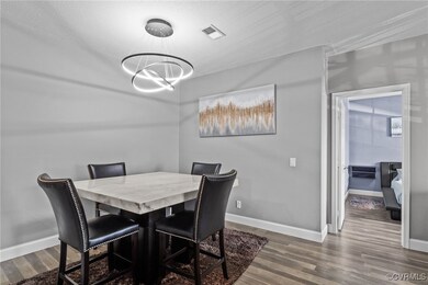 Dining room featuring baseboards, dark wood-style flooring, visible vents, and an inviting chandelier