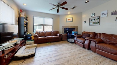 Living room with a fireplace, recessed lighting, v