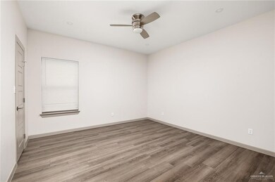 Spare room featuring ceiling fan, light wood finished floors, and baseboards