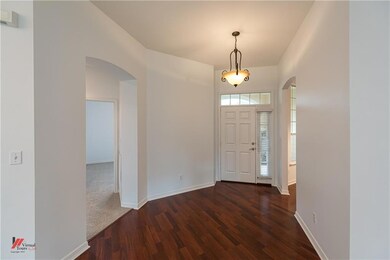 Wood like vinyl floors run through the entry, brea