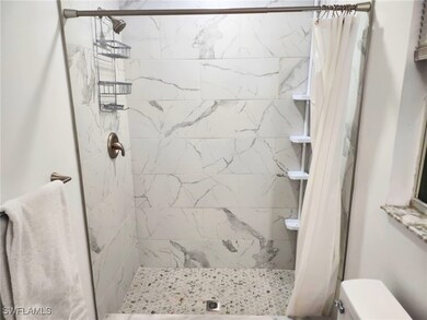 Bathroom featuring a shower with shower curtain an