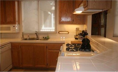 Kitchen with gas stove/oven and tile floor.