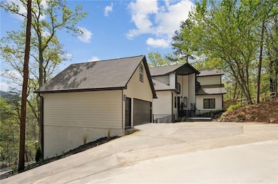 View of front of property with an attached garage, a shingled roof, and concrete driveway