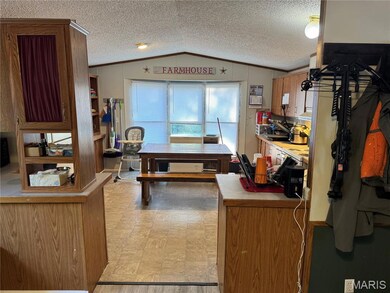 Office area featuring a textured ceiling, vaulted ceiling, and ornamental molding