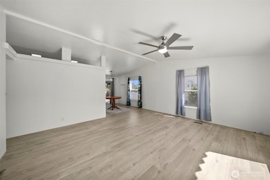 Living room with remote controlled ceiling fan and newer flooring.