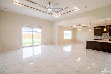 Unfurnished living room featuring a tray ceiling, light marble finish flooring, ceiling fan, and recessed lighting