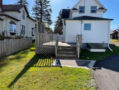 Rear view of property featuring a wooden deck and 