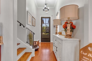 Entrance foyer with ornamental molding and light wood finished floors