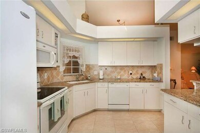 Kitchen with window looking out to front screened patio area