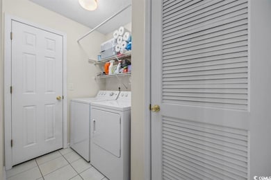Laundry room with a textured ceiling, washing mach
