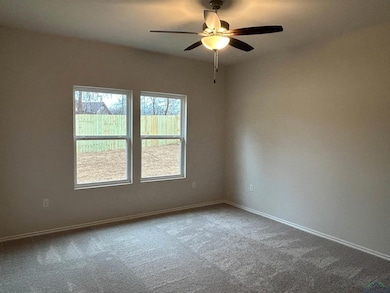 Carpeted empty room featuring ceiling fan