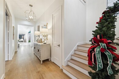 Gracious entry has wide hardwood floors, hidden st