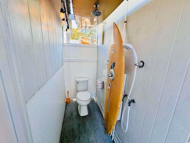 Bathroom with toilet, hardwood / wood-style floori
