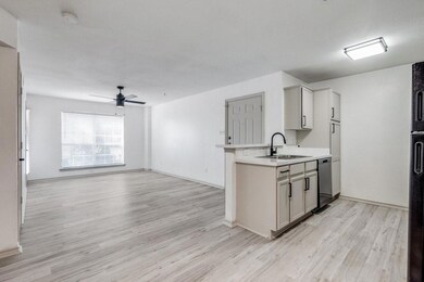 Kitchen with dishwasher, a sink, light countertops