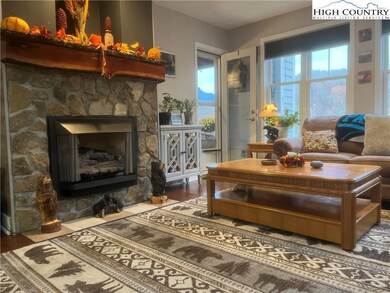 Fireplace w/ Stone & Handcrafted Mantle, beside Glass Door to View Deck