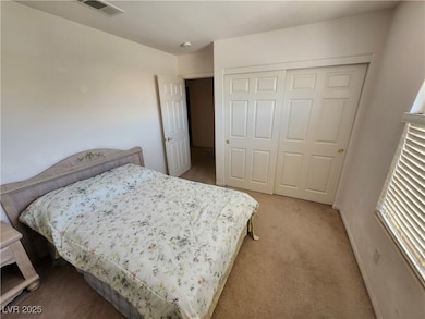Bedroom featuring light carpet and a closet