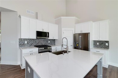 Kitchen featuring visible vents, a high ceiling, a