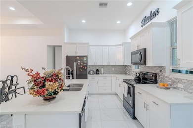Dining area with recessed lighting, visible vents, an inviting chandelier, and a raised ceiling