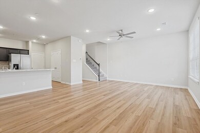Unfurnished living room featuring ceiling fan and light hardwood / wood-style floors