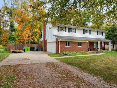 Traditional-style home with driveway, brick siding, an attached garage, and a porch